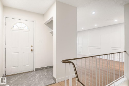 Entryway featuring a white door with an arched window, grey tiled flooring, and a built-in shelf - 6540 184 Street, Edmonton, AB - Indoor Photo Showing Other Room