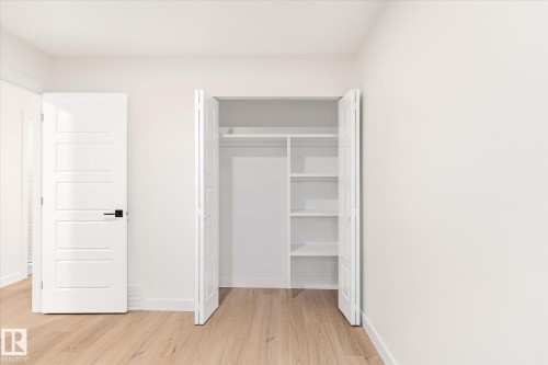 Room featuring light-toned flooring, white walls, and a closet with shelving and a hanging rod - 6540 184 Street, Edmonton, AB - Indoor