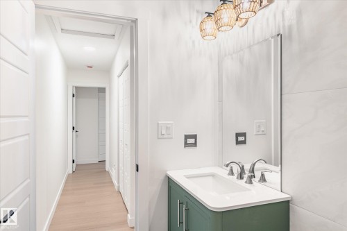 The property features a hallway with light-colored flooring and white walls, leading to additional rooms - 6540 184 Street, Edmonton, AB - Indoor Photo Showing Bathroom