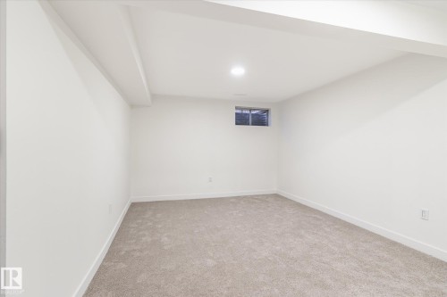 This room features plush grey carpeting, white walls, and a window providing natural light - 6540 184 Street, Edmonton, AB - Indoor Photo Showing Other Room