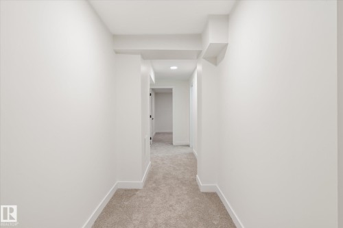 This hallway features light-colored walls, recessed lighting, and carpeting - 6540 184 Street, Edmonton, AB - Indoor Photo Showing Other Room