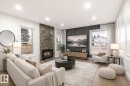 The living area features a stone fireplace, large windows, and recessed lighting - 6540 184 Street, Edmonton, AB  - Indoor Photo Showing Living Room With Fireplace 