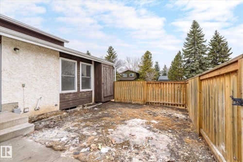 The property features exterior stucco siding and wood paneling, along with a newly installed wooden fence - 6540 184 Street, Edmonton, AB - Outdoor
