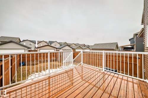 The property features an outdoor deck with a wooden surface and white railings, overlooking a fenced yard - 5868 Anthony Crescent, Edmonton, AB - Outdoor With Deck Patio Veranda With Exterior