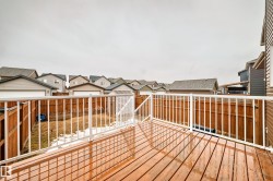 The property features an outdoor deck with a wooden surface and white railings, overlooking a fenced yard - 