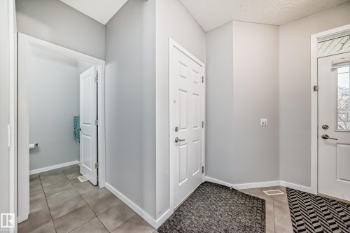The property features a bright entryway with light gray walls, white trim, and neutral-toned floor tiles - 5868 Anthony Crescent, Edmonton, AB - Indoor Photo Showing Other Room