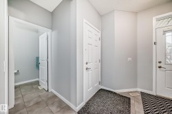 The property features a bright entryway with light gray walls, white trim, and neutral-toned floor tiles - 