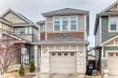 The property features a two-story design with a garage, stone facade accents, and a grey shingle roof - 5868 Anthony Crescent, Edmonton, AB  - Outdoor With Facade 