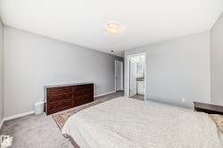 The room features light gray walls, a ceiling light fixture, and a neutral-toned carpet - 