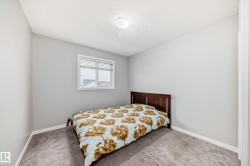 The room features light gray walls, a window with blinds, and carpeted flooring - 