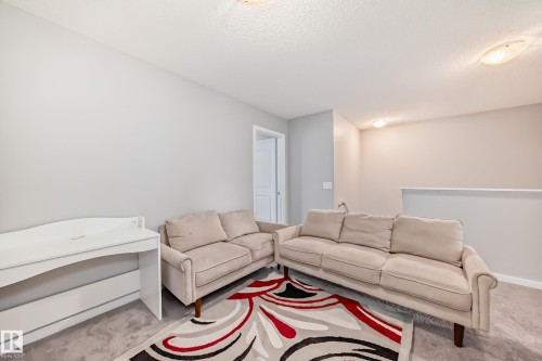 This versatile space features carpeting, light neutral walls, and overhead lighting, offering flexibility for various uses - 5868 Anthony Crescent, Edmonton, AB - Indoor Photo Showing Living Room