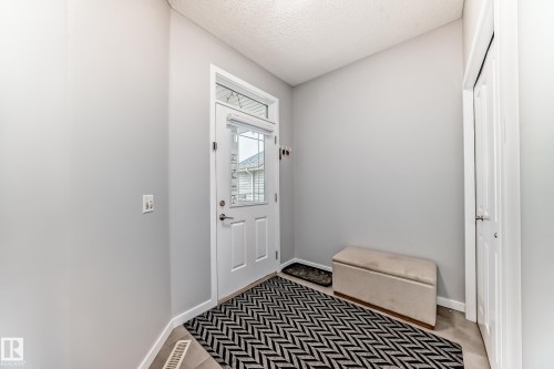 The entrance features a white door with a window, light gray walls, and light-colored flooring - 5868 Anthony Crescent, Edmonton, AB - Indoor Photo Showing Other Room