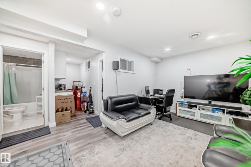 Spacious living area featuring light-toned walls, recessed lighting, and durable flooring, providing a versatile space for various activities - 5868 Anthony Crescent, Edmonton, AB - Indoor