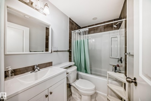 Bathroom featuring a vanity with an integrated sink, a toilet, and a shower-tub combination with tile surround - 5868 Anthony Crescent, Edmonton, AB - Indoor Photo Showing Bathroom