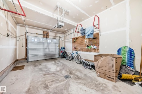 The property includes a spacious garage with an automatic overhead door and a concrete floor - 5868 Anthony Crescent, Edmonton, AB - Indoor Photo Showing Garage