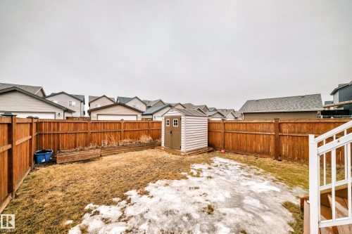 The property features a fenced yard with a storage shed and a white staircase leading to the outdoor space - 5868 Anthony Crescent, Edmonton, AB - Outdoor
