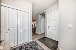 Entryway featuring tile flooring, white paneled doors, and light gray walls - 