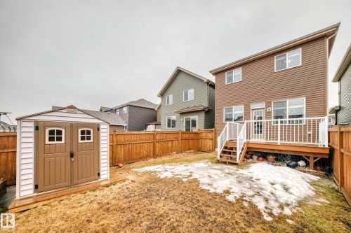 The property features a private yard with a wooden fence, a storage shed, and a wooden deck with white railings - 5868 Anthony Crescent, Edmonton, AB - Outdoor With Deck Patio Veranda With Exterior