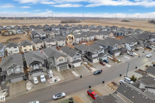 Aerial view showcasing the property within a residential neighborhood featuring detached homes with attached garages, and a clear sky with visible clouds - 3235 13 Avenue, Edmonton, AB - Outdoor With View