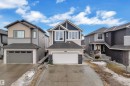 The property features a dark grey roof, a two-car garage with a white door, and a light-colored exterior with dark trim - 3235 13 Avenue, Edmonton, AB  - Outdoor With Facade 