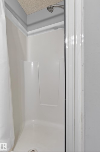 Shower stall with a white base and walls, featuring a chrome showerhead - 131 2098 Blackmud Creek Drive Sw, Edmonton, AB - Indoor Photo Showing Bathroom