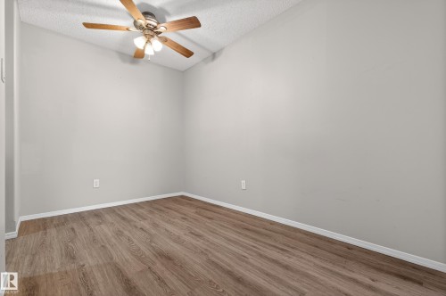 This room features light-colored walls and wood-look flooring, complemented by a ceiling fan with integrated lighting - 131 2098 Blackmud Creek Drive Sw, Edmonton, AB - Indoor Photo Showing Other Room