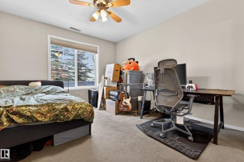 This room features a window providing natural light, carpeted flooring, and a ceiling fan - 131 2098 Blackmud Creek Drive Sw, Edmonton, AB - Indoor Photo Showing Bedroom