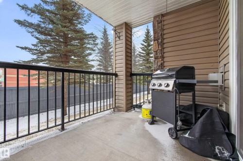 This outdoor balcony features a concrete floor and a black metal railing - 131 2098 Blackmud Creek Drive Sw, Edmonton, AB - Outdoor With Balcony With Exterior