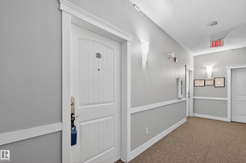 This property features a white paneled entrance door with a door number, set within a gray hallway with white trim - 131 2098 Blackmud Creek Drive Sw, Edmonton, AB - Indoor Photo Showing Other Room