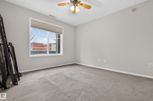 The room features a window with blinds, carpeted flooring, and a ceiling fan with a light fixture - 131 2098 Blackmud Creek Drive Sw, Edmonton, AB - Indoor Photo Showing Other Room