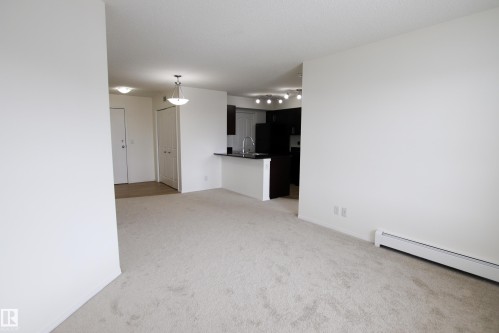 The property features an open-concept living area with light-colored carpeted flooring - 405 534 Watt Boulevard, Edmonton, AB - Indoor Photo Showing Other Room