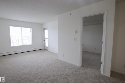 This inviting space features light-colored carpeting, white walls, and a window with blinds, allowing for natural illumination - 405 534 Watt Boulevard, Edmonton, AB - Indoor Photo Showing Other Room
