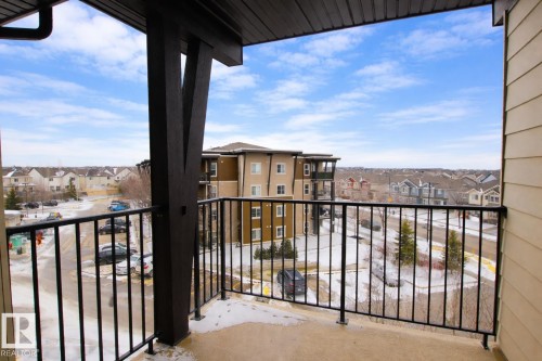 The property features a balcony with a black metal railing and views of the surrounding neighborhood and buildings - 405 534 Watt Boulevard, Edmonton, AB - Outdoor With Exterior