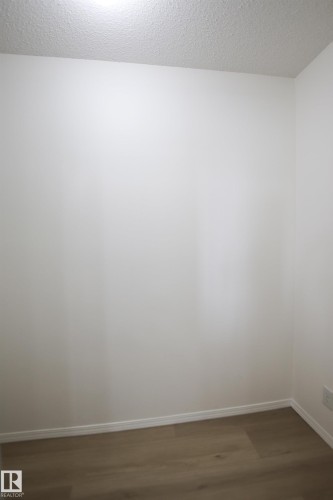 This area features light-colored walls, a textured ceiling, and light wood-style flooring - 405 534 Watt Boulevard, Edmonton, AB - Indoor Photo Showing Other Room