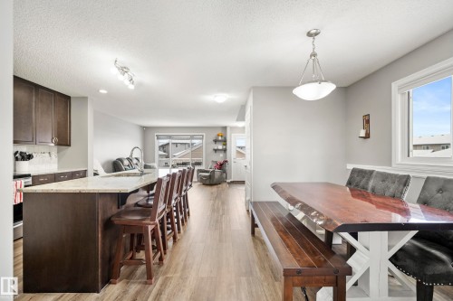 This open concept living area features light-colored walls and wood-look flooring throughout - 635 41 Avenue, Edmonton, AB - Indoor Photo Showing Dining Room