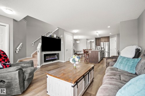 Living area featuring light wood-style flooring, a wall-mounted fireplace, and recessed lighting - 635 41 Avenue, Edmonton, AB - Indoor Photo Showing Living Room With Fireplace