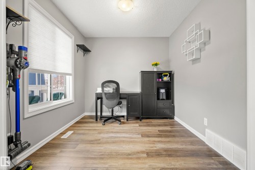 This room features light-colored walls, wood-style flooring, a window with horizontal blinds, and a built-in desk area - 635 41 Avenue, Edmonton, AB - Indoor Photo Showing Office