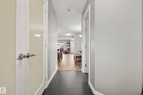 Inviting hallway with dark tile flooring, leading into an area with light wood flooring - 635 41 Avenue, Edmonton, AB - Indoor Photo Showing Other Room