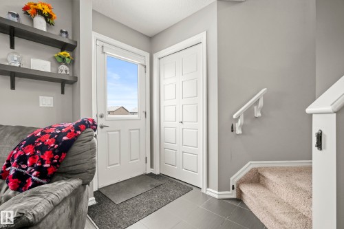 This entry area features a bright white door with a window, tile flooring, and a nearby closet with bi-fold doors - 635 41 Avenue, Edmonton, AB - Indoor