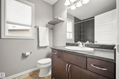 The bathroom features a vanity with a countertop and an integrated sink, a toilet, and a window with blinds - 635 41 Avenue, Edmonton, AB - Indoor Photo Showing Bathroom