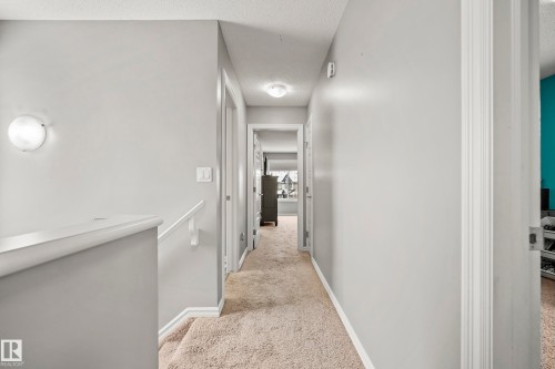 A well-lit interior hallway with light-colored walls and carpeted flooring - 635 41 Avenue, Edmonton, AB - Indoor Photo Showing Other Room