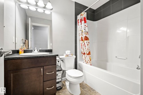 Bathroom featuring a vanity with a dark countertop, an integrated sink, and a mirror with overhead lighting - 635 41 Avenue, Edmonton, AB - Indoor Photo Showing Bathroom