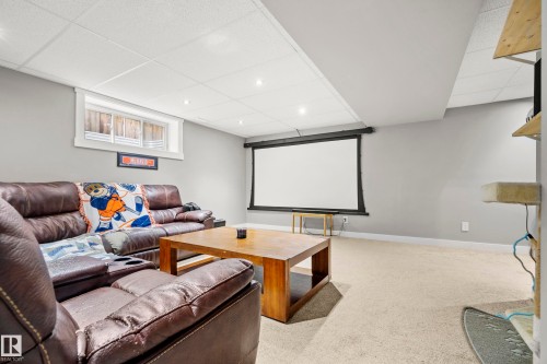 This spacious area features light grey walls and carpeted flooring, providing a versatile space - 635 41 Avenue, Edmonton, AB - Indoor