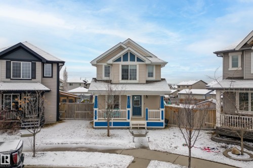 The property features a two-story design with light-colored siding and a contrasting blue trim on the front porch - 635 41 Avenue, Edmonton, AB - Outdoor With Deck Patio Veranda