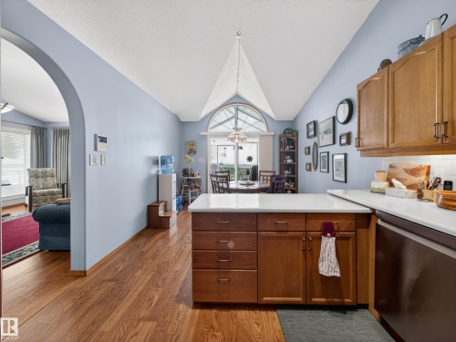 The kitchen features wood cabinetry, white countertops, and a white tile backsplash - 7 85 Gervais Road, St. Albert, AB - Indoor Photo Showing Kitchen