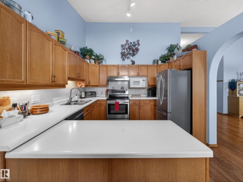 The kitchen features light wood cabinetry, stainless steel appliances, and white countertops - 7 85 Gervais Road, St. Albert, AB - Indoor Photo Showing Kitchen With Double Sink
