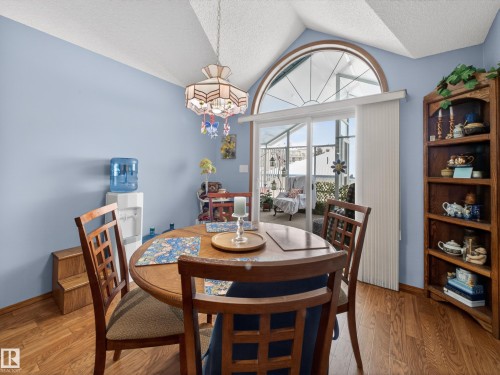 This dining area features wood flooring and a vaulted ceiling with an overhead light fixture - 7 85 Gervais Road, St. Albert, AB - Indoor Photo Showing Dining Room