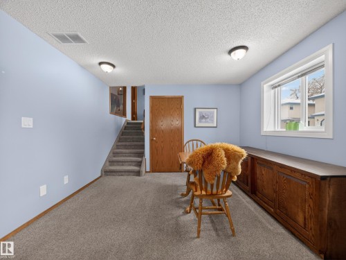 The property features a room with light blue walls and gray carpet, illuminated by two ceiling lights - 7 85 Gervais Road, St. Albert, AB - Indoor Photo Showing Other Room