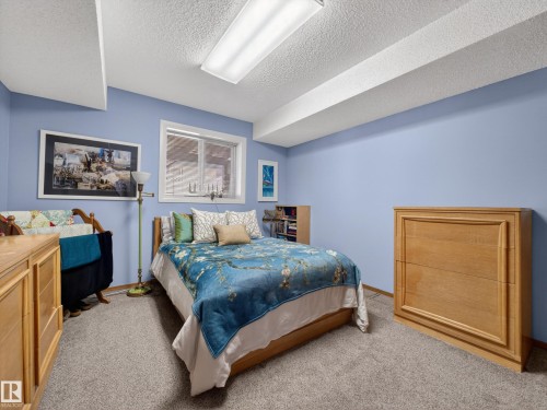 This room features light blue walls, a window with a white frame, and wall-to-wall carpeting - 7 85 Gervais Road, St. Albert, AB - Indoor Photo Showing Bedroom