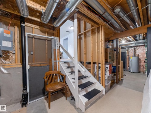The property features unfinished basement space with exposed wooden beams, ductwork, and a staircase - 7 85 Gervais Road, St. Albert, AB - Indoor Photo Showing Basement